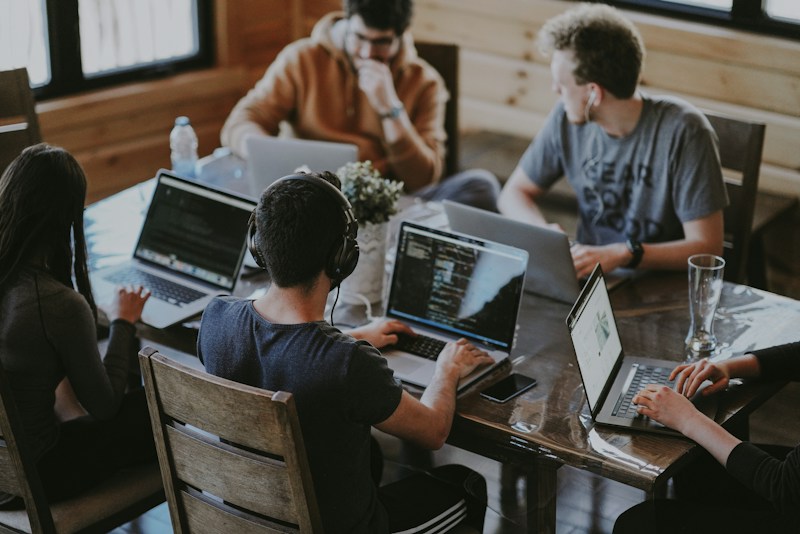 Digital team collaborating around laptops to connect strategy with hands-on execution